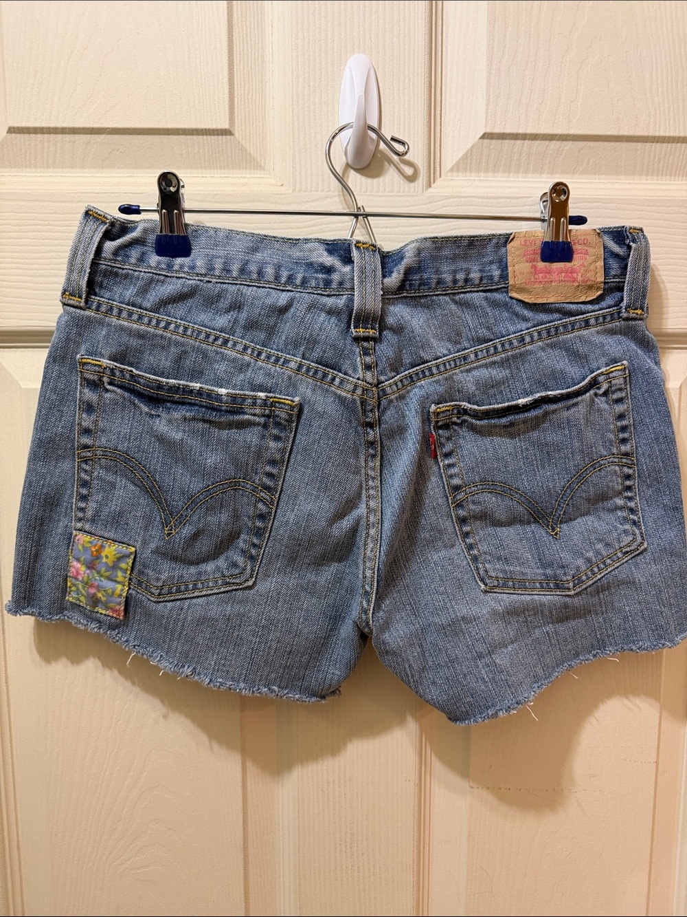 Levi's 513 button fly cutoffs with floral patch
